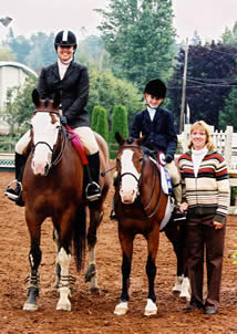 Danalynn standing on right with two riders